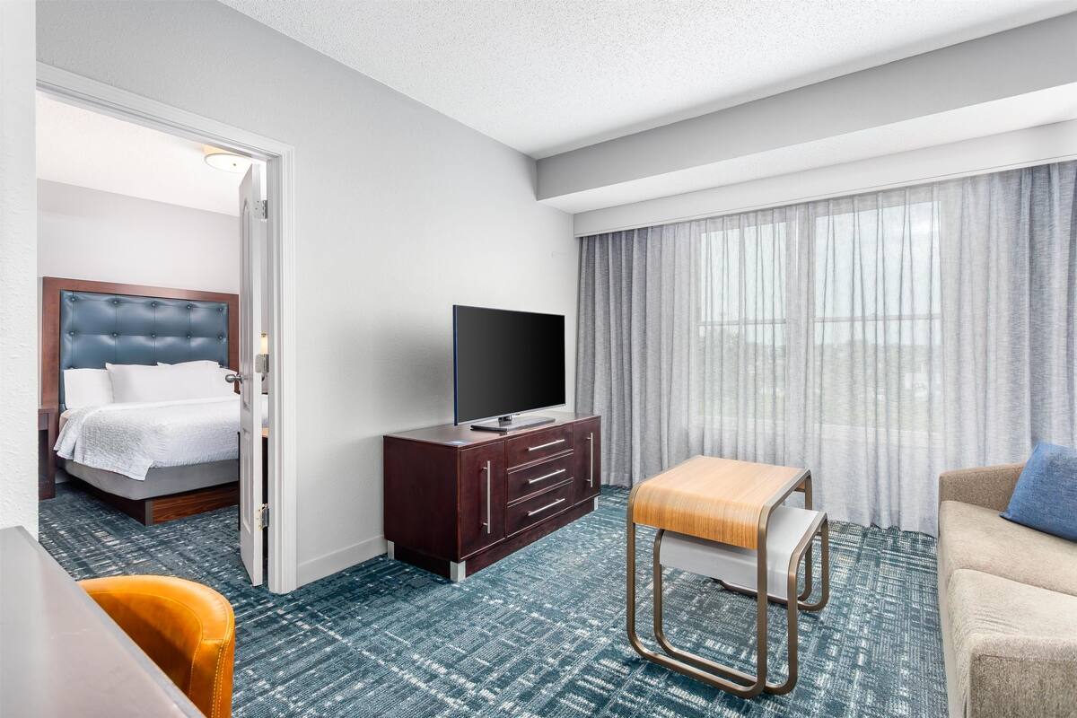 Een hotelkamer met een bed, een televisie, een bureau en een bank.