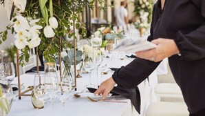 A table set for a formal event with glassware, plates, and cutlery.