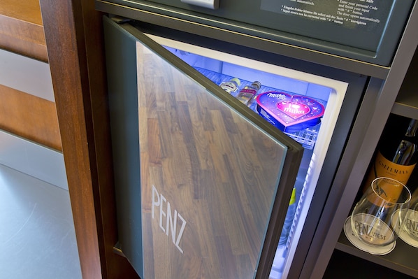 Un refrigerador con interior de madera y una botella de vino visible.