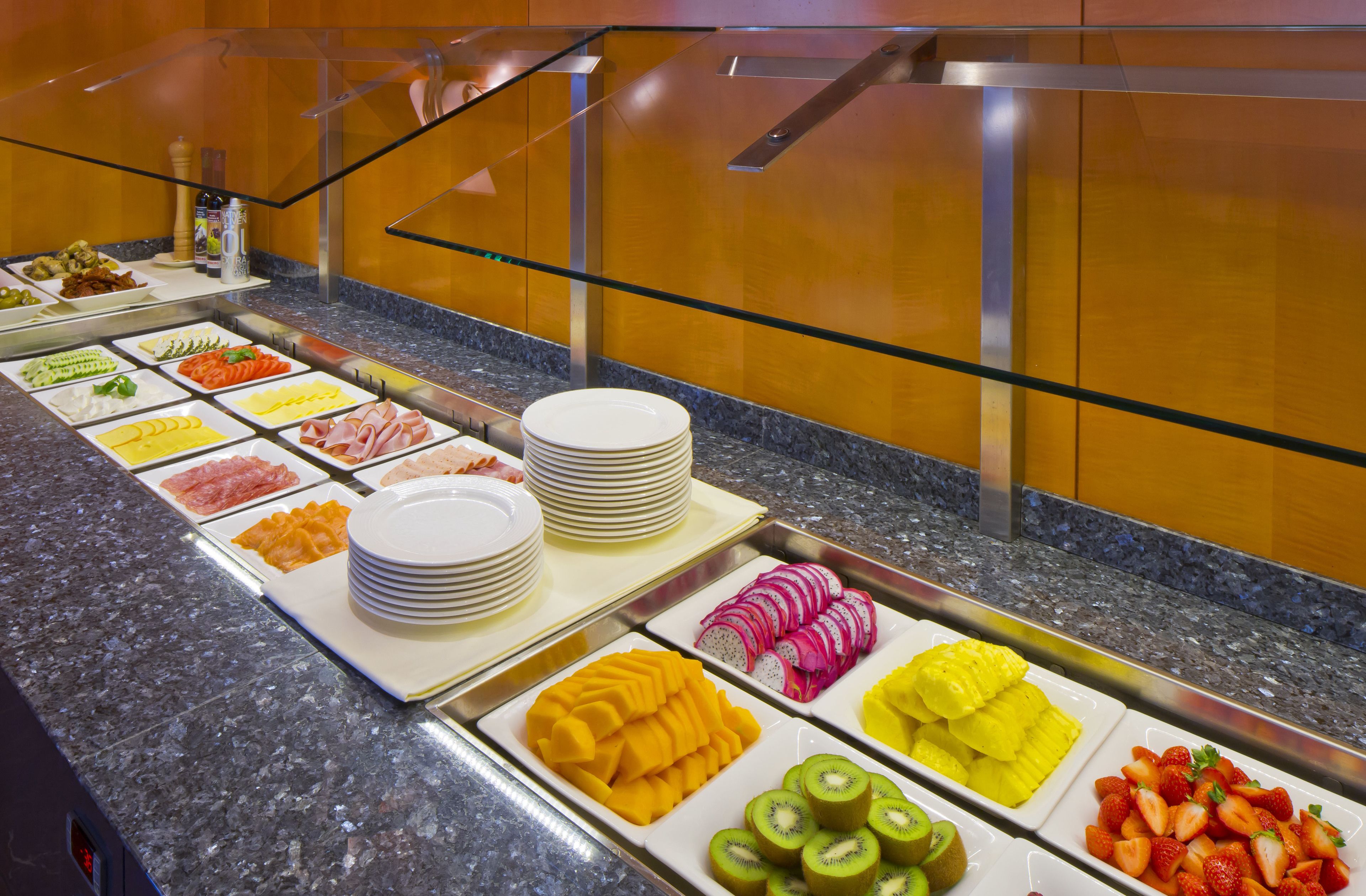 A buffet with various food items including fruits, vegetables, and meats.