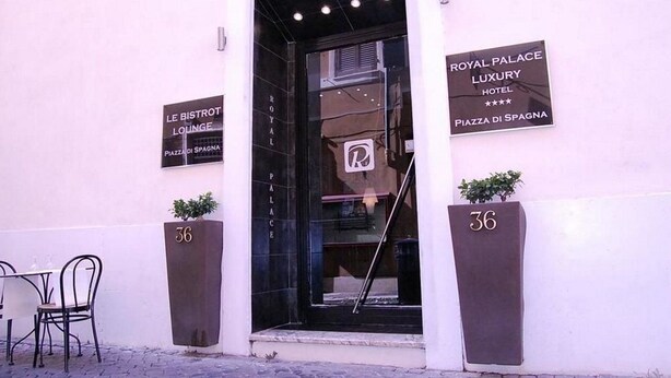 Entrada a l'Hotel Royal Palace Luxury a la Plaça de l'Espanya, amb un rètol que indica la seva ubicació.