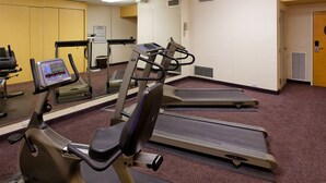 Et træningscenter med løbebånd, crosstrainer og motionscykel.