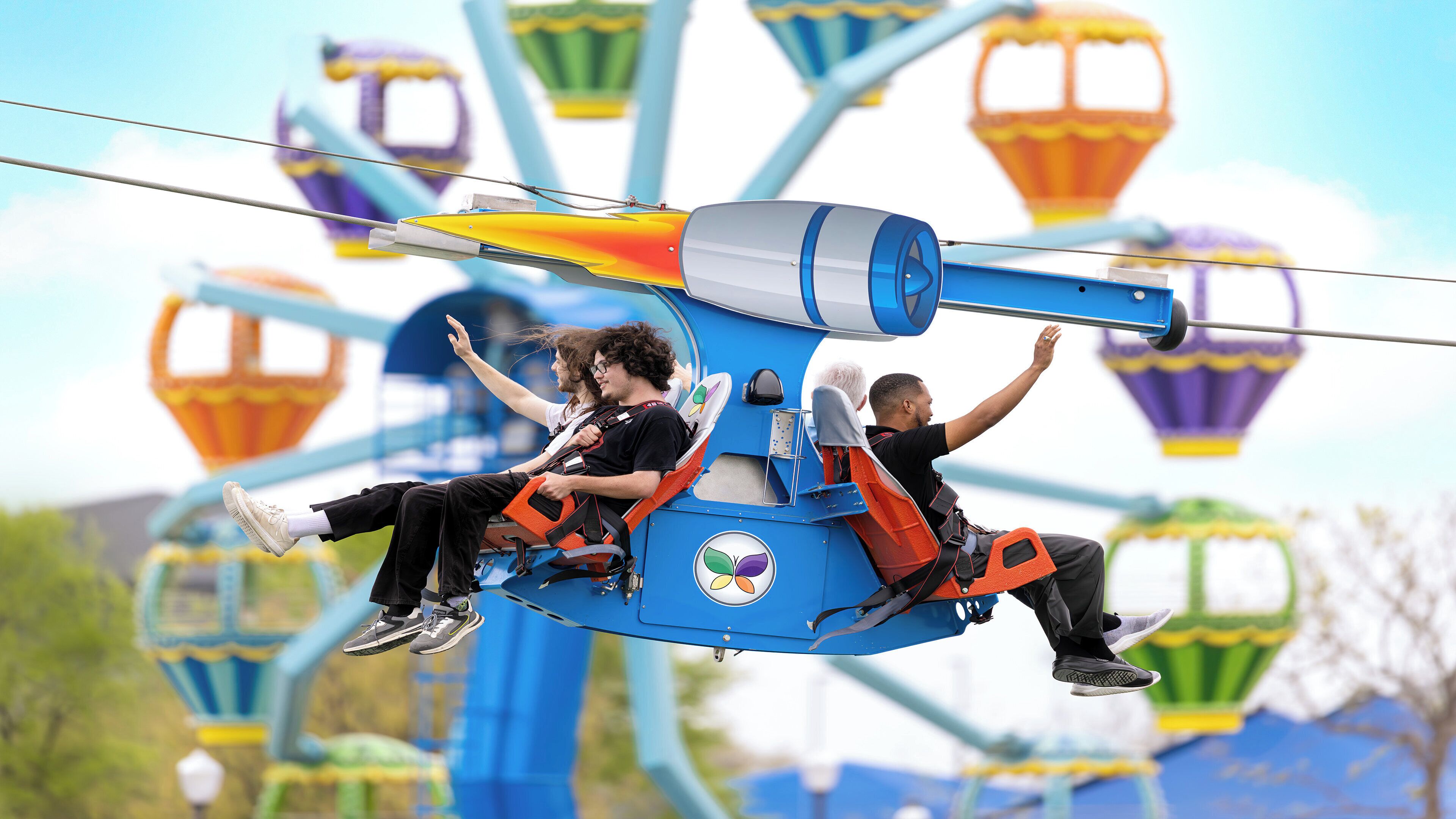 A ride with two passengers, one wearing a black shirt and the other in a white shirt, on a blue and orange ride vehicle.