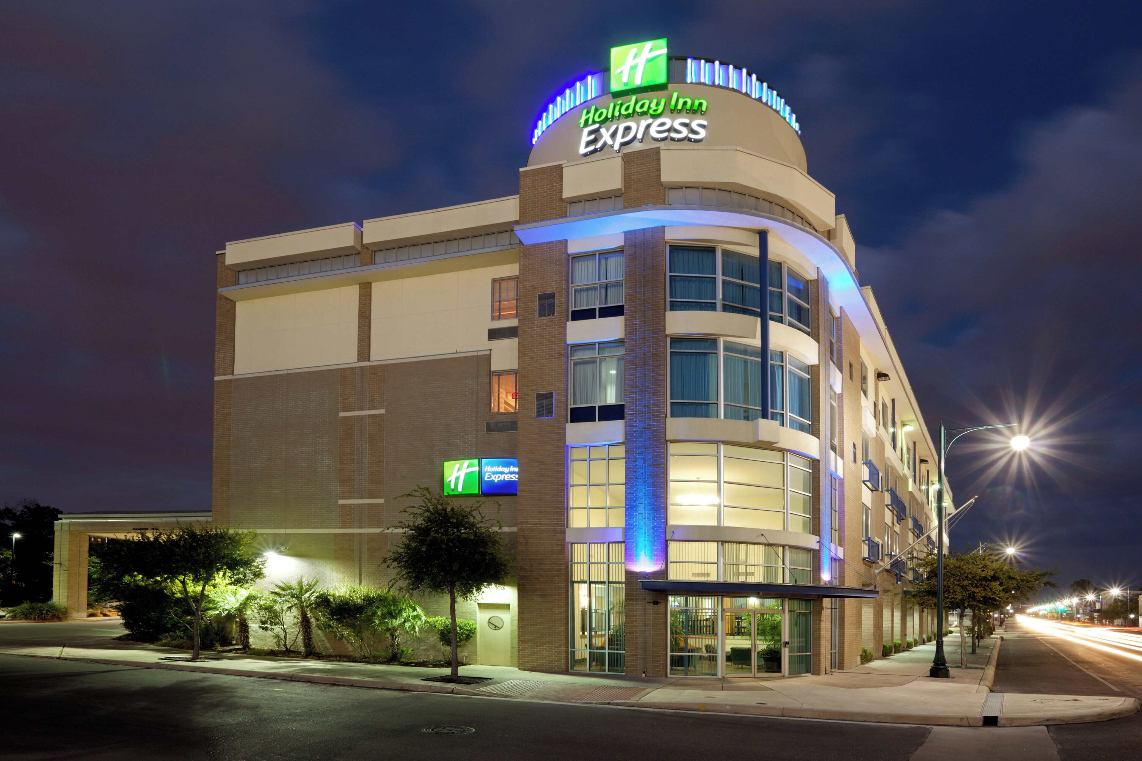 A Holiday Inn Express hotel with a curved facade, large windows, and a prominent sign.