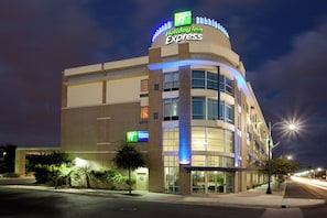 Ein Holiday Inn Express Hotel mit gebogener Fassade, großen Fenstern und einer auffälligen Beschilderung.