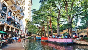Un canal con barcos, un puente peatonal y un edificio con balcones.