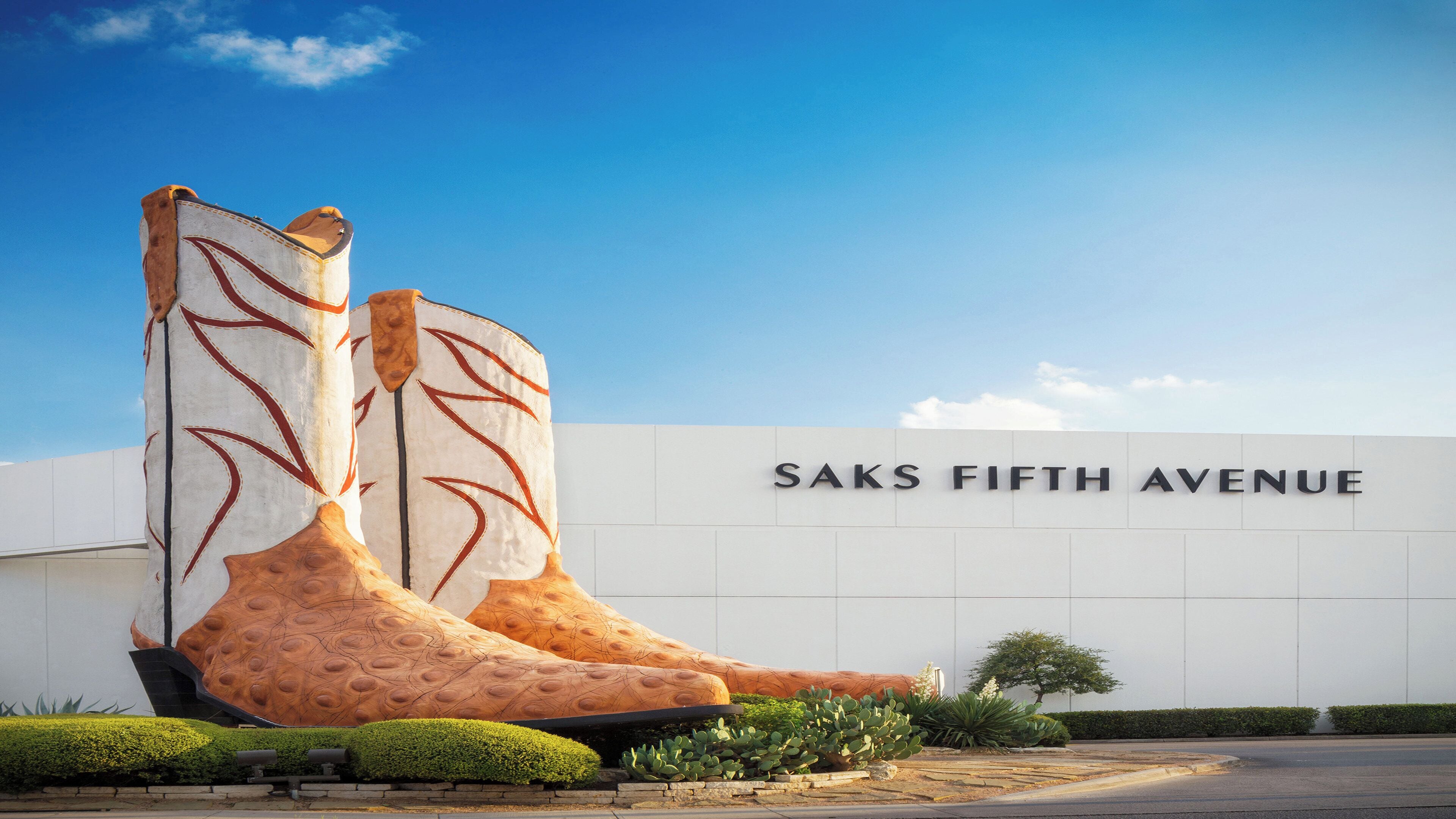 Un bâtiment orné d’une grande sculpture représentant une botte géante, et sur lequel on peut lire l’inscription « SAKS FIFTH AVENUE ».