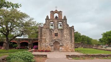 An old stone church with a bell tower, arched windows, and a central door.