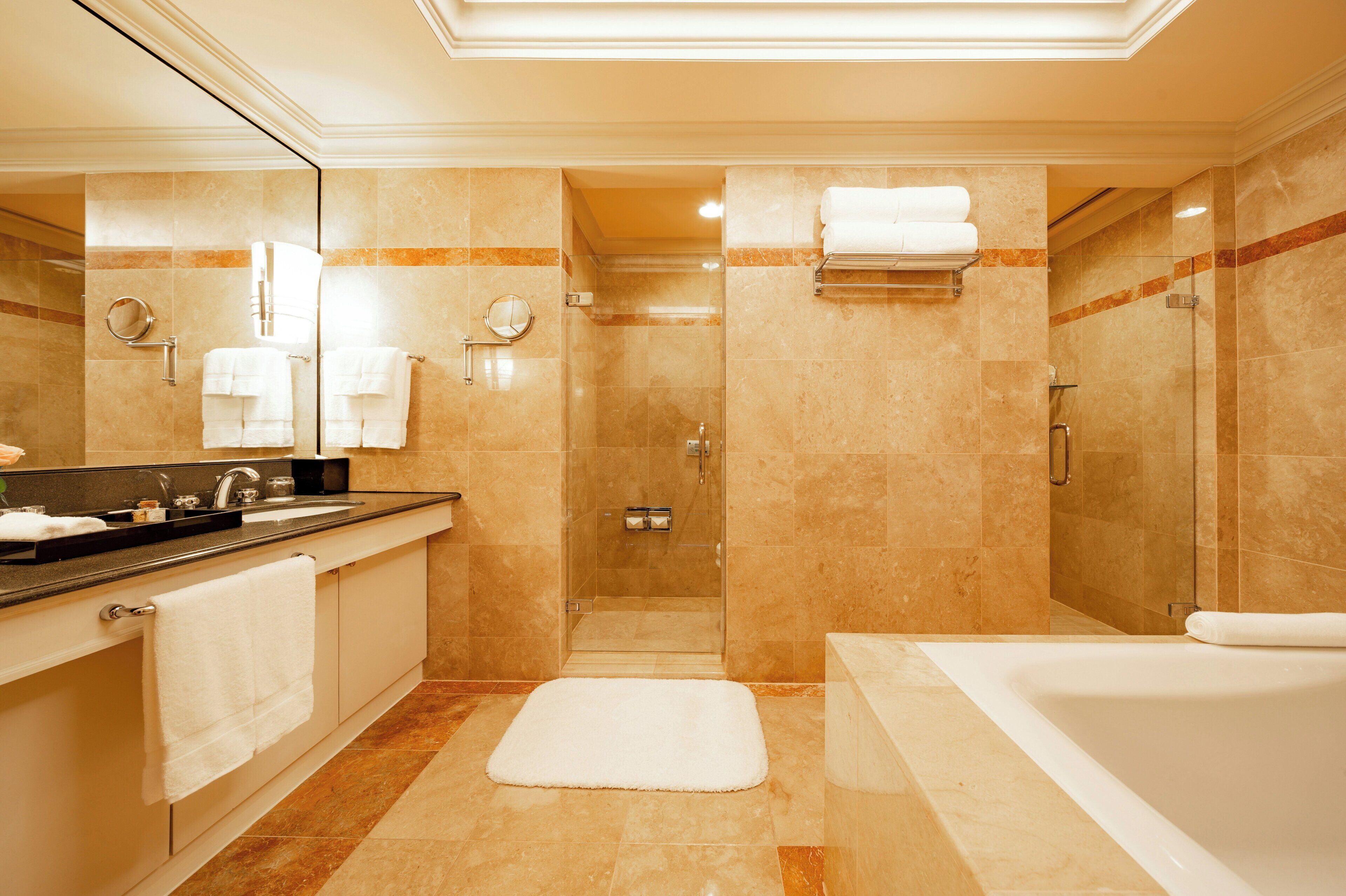 A modern bathroom with a bathtub, a shower area, and a vanity with a mirror and sink.