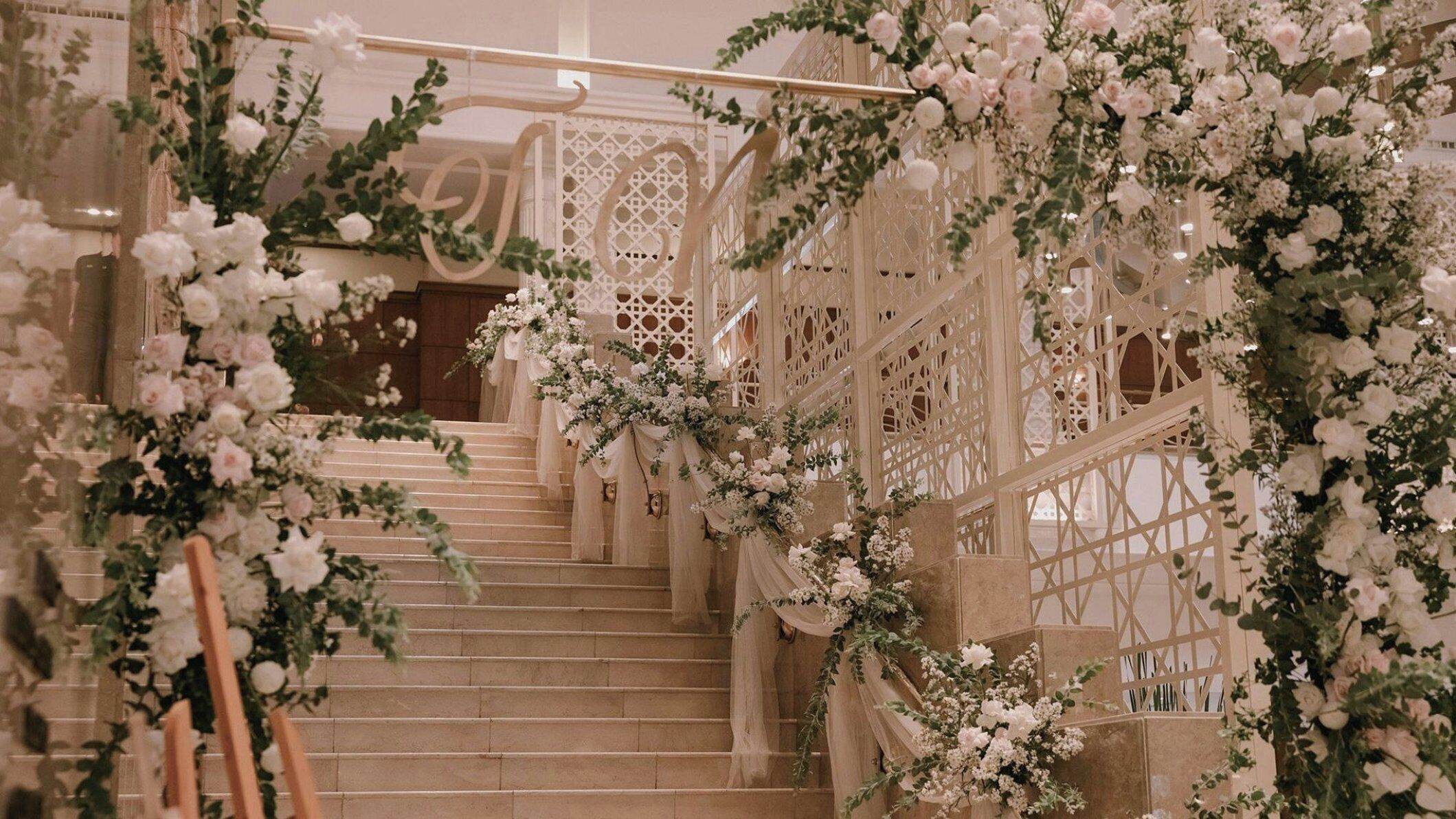 A staircase with white floral decorations and a wooden railing.