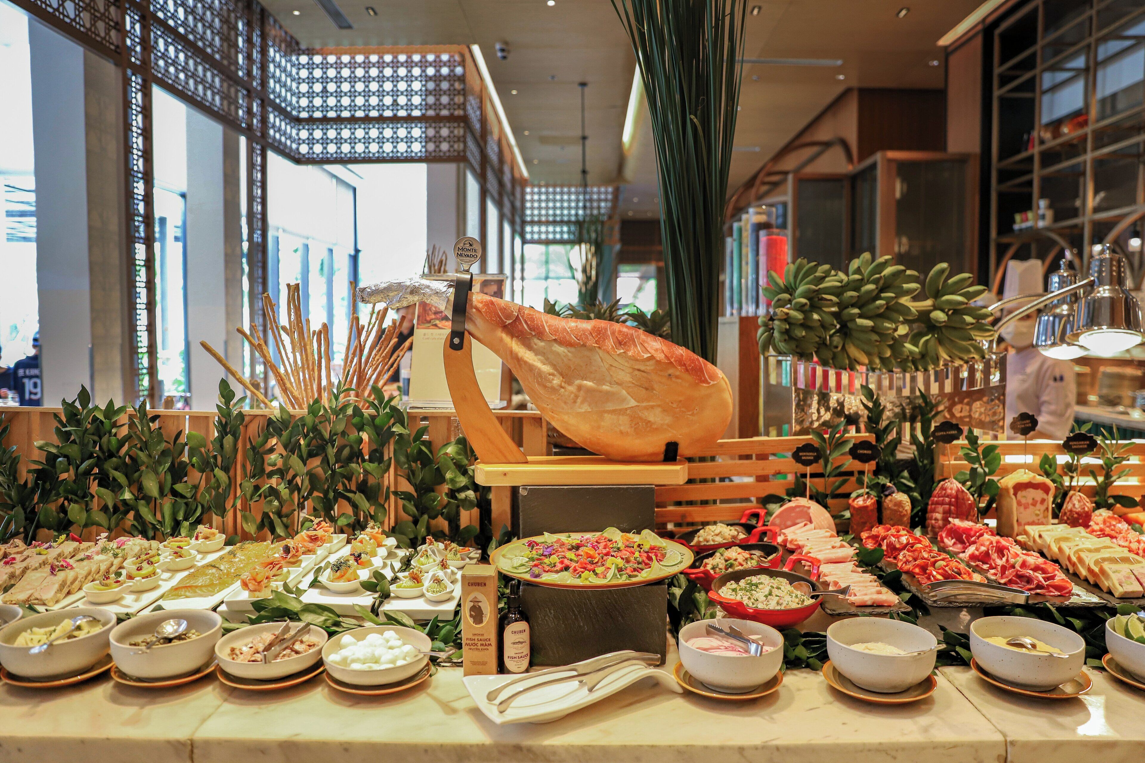 A buffet with various food items and a large hanging bread.