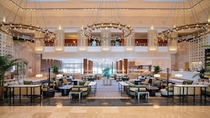 A spacious lobby with a central seating area, high ceilings, and modern chandeliers. - Lotte Hotel Saigon (Ho Chi Minh City)
