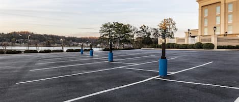 An empty parking lot with marked parking spaces and bollards.