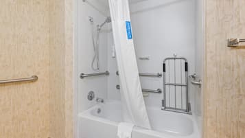 A bathroom with a bathtub, shower, grab bars, and a white curtain.