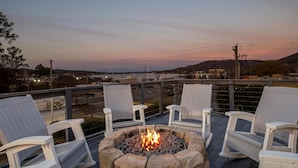 A deck with a fire pit and white Adirondack chairs, overlooking a distant landscape. - Hampton Inn Guntersville (Guntersville)
