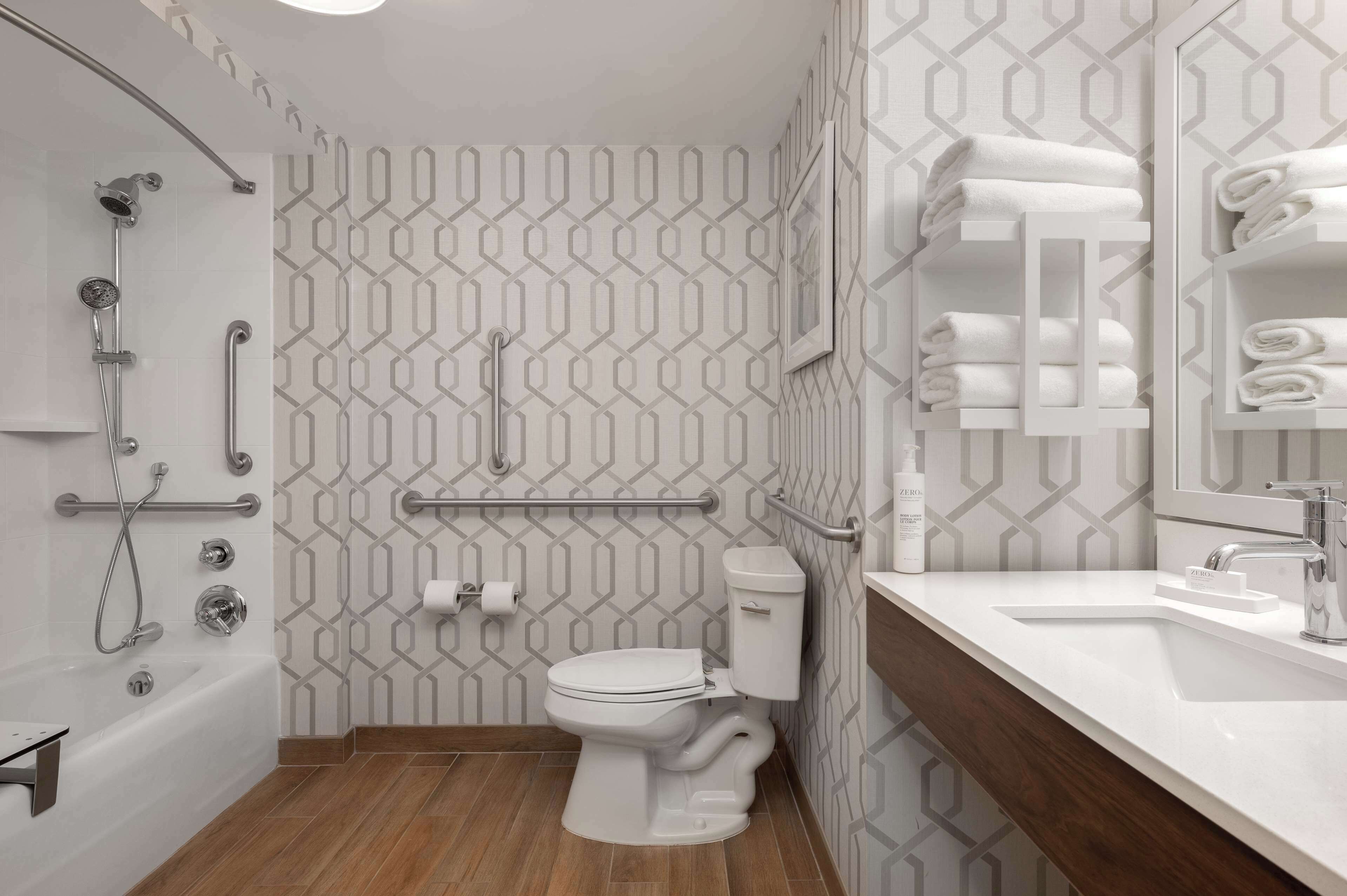 A modern bathroom with a shower, toilet, and sink.