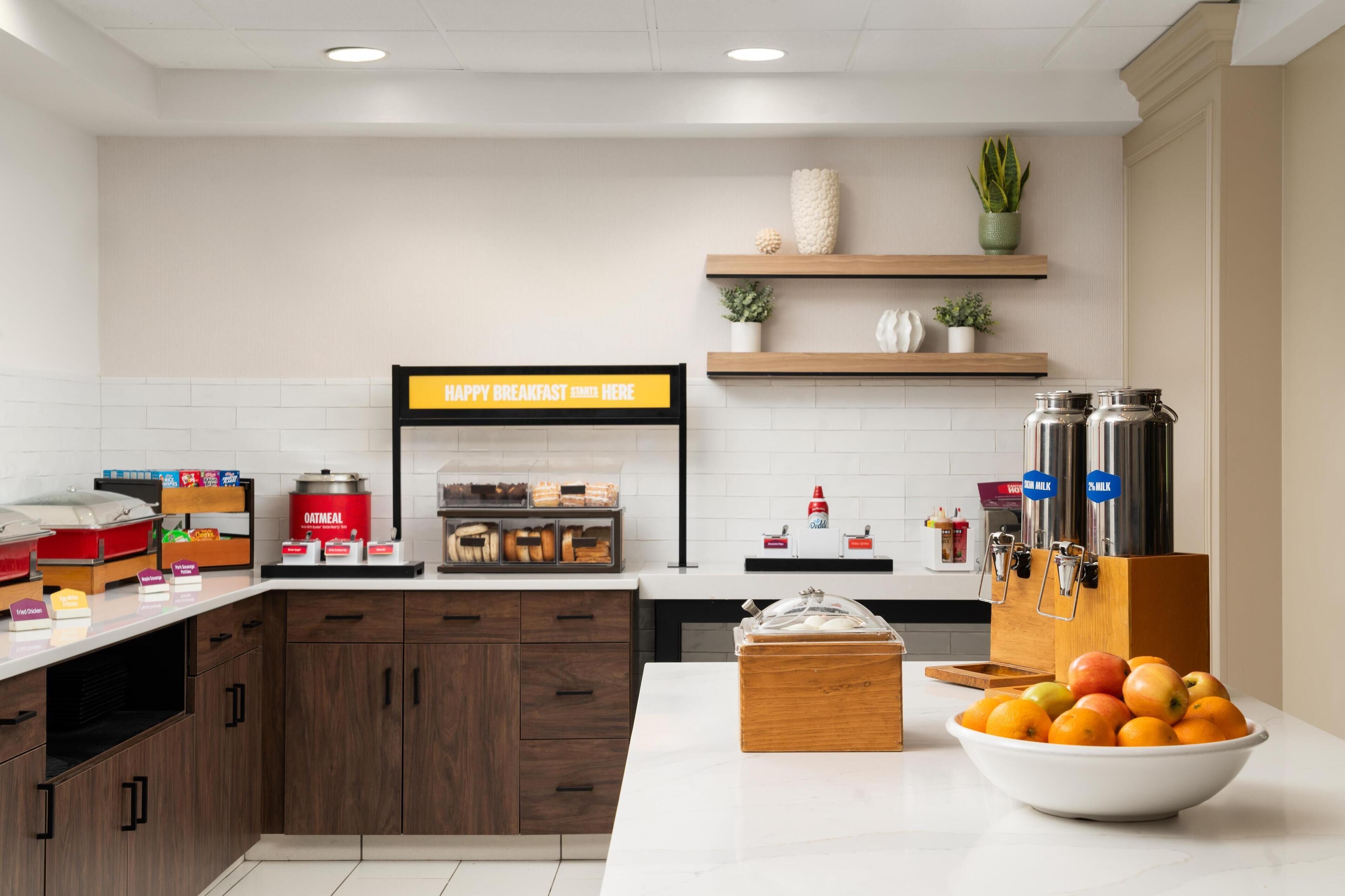 Een moderne keuken met een ontbijtbalk, een bordje met tekst en diverse etenswaren.