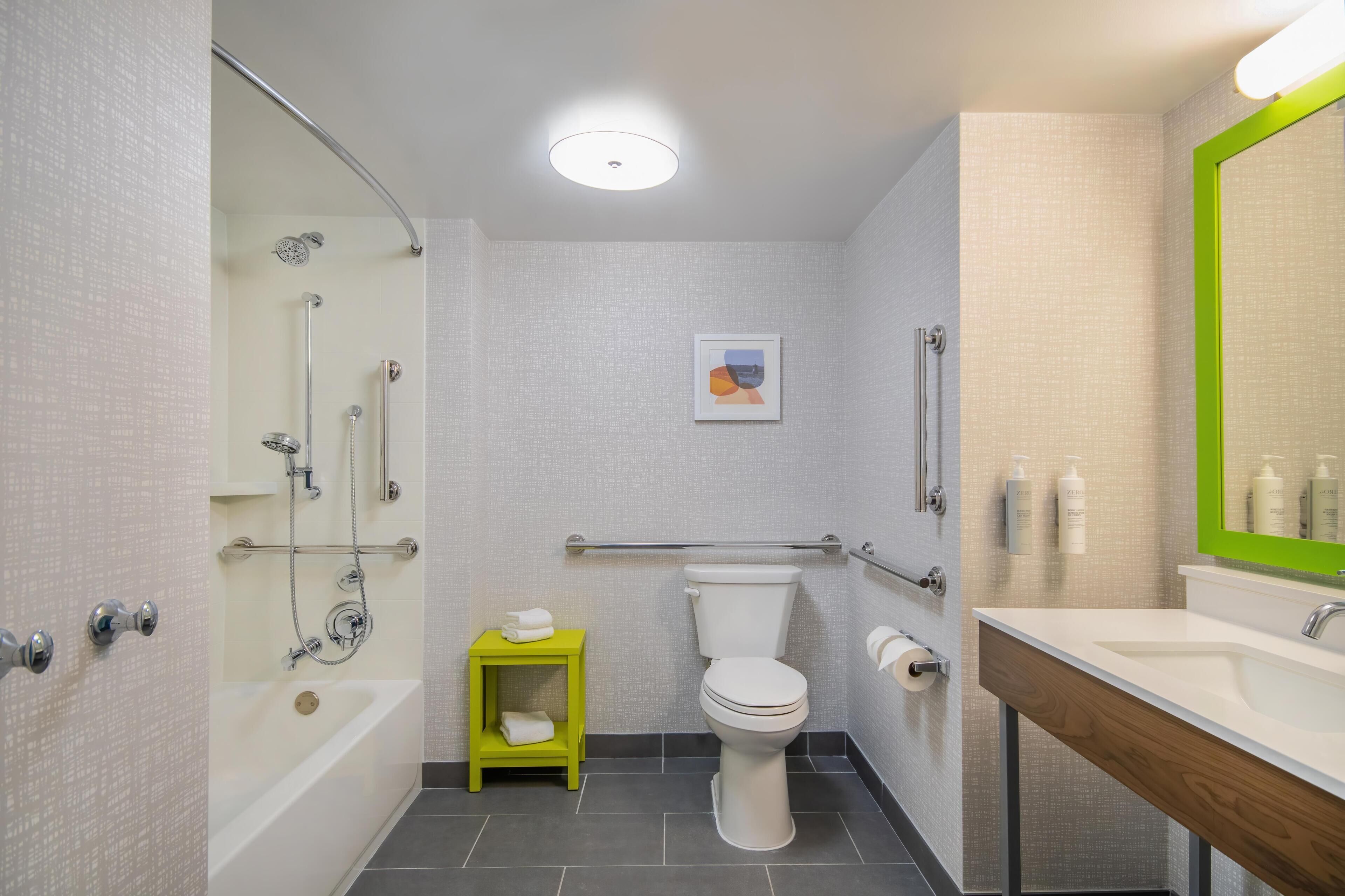 A modern bathroom with a shower, toilet, and sink.