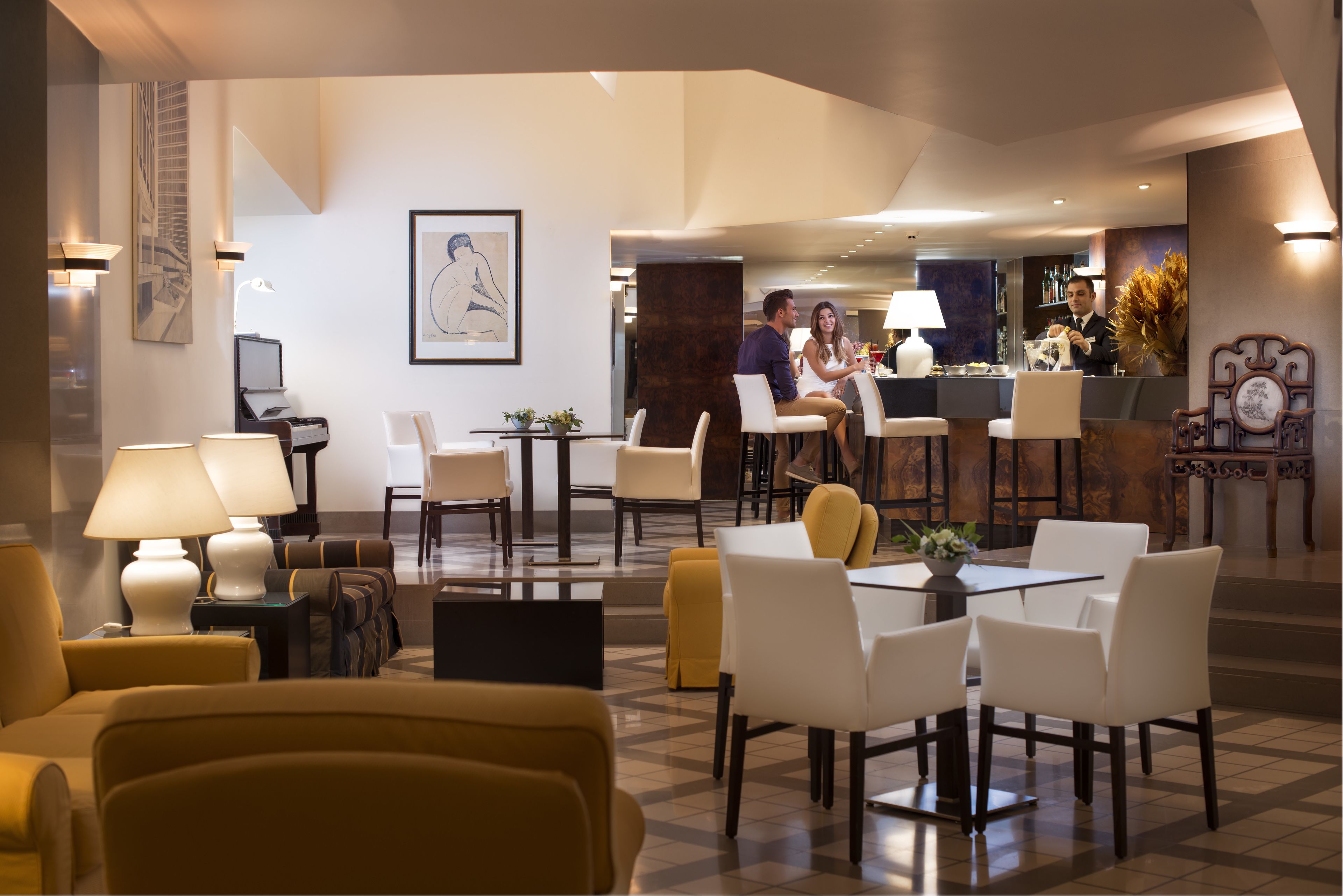 Un vestíbulo de hotel con mostrador de recepción, zona de estar y bar.