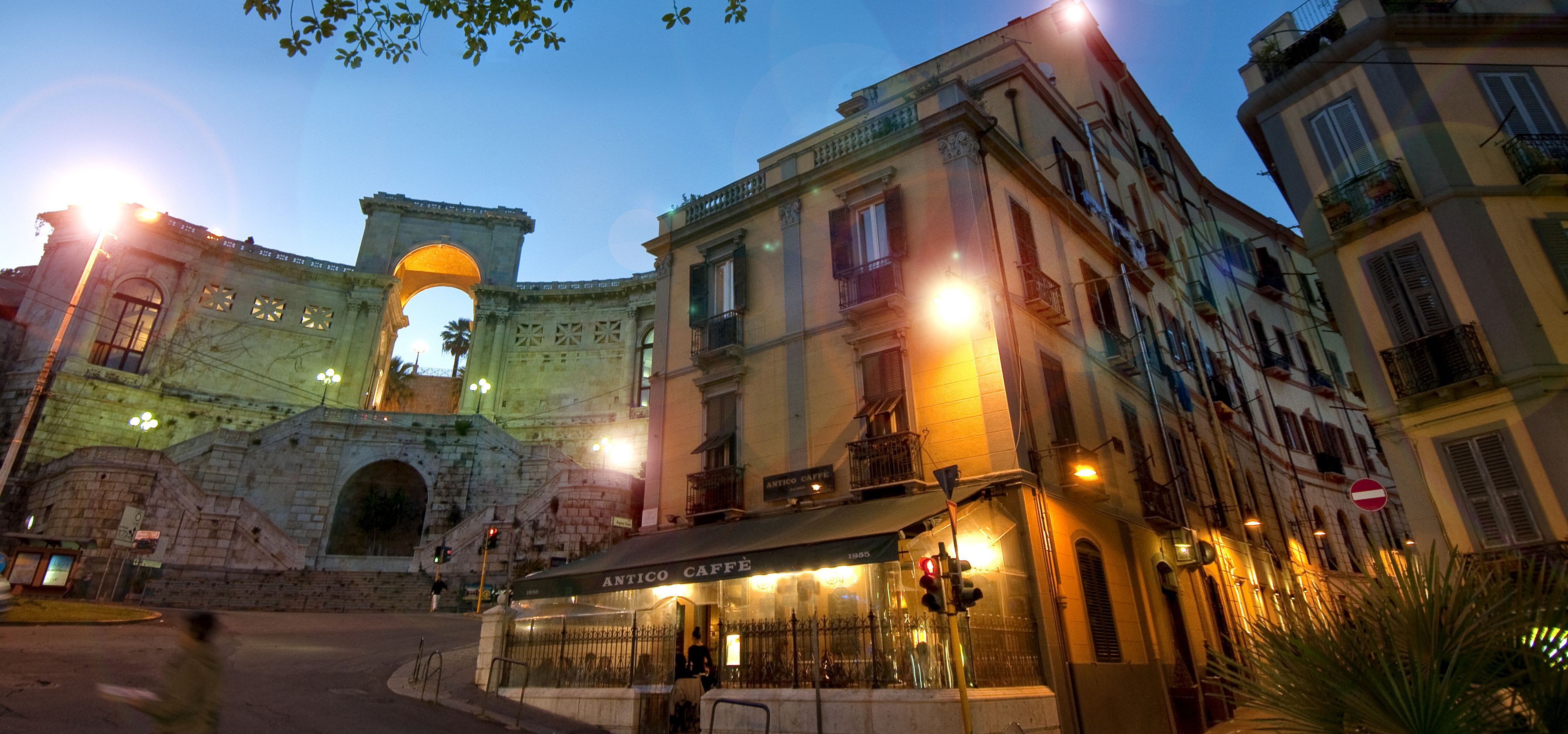 A historic archway with a cafe named "Antico Caffè" in front.