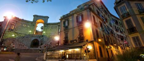 A historic archway with a cafe named "Antico Caffè" in front.