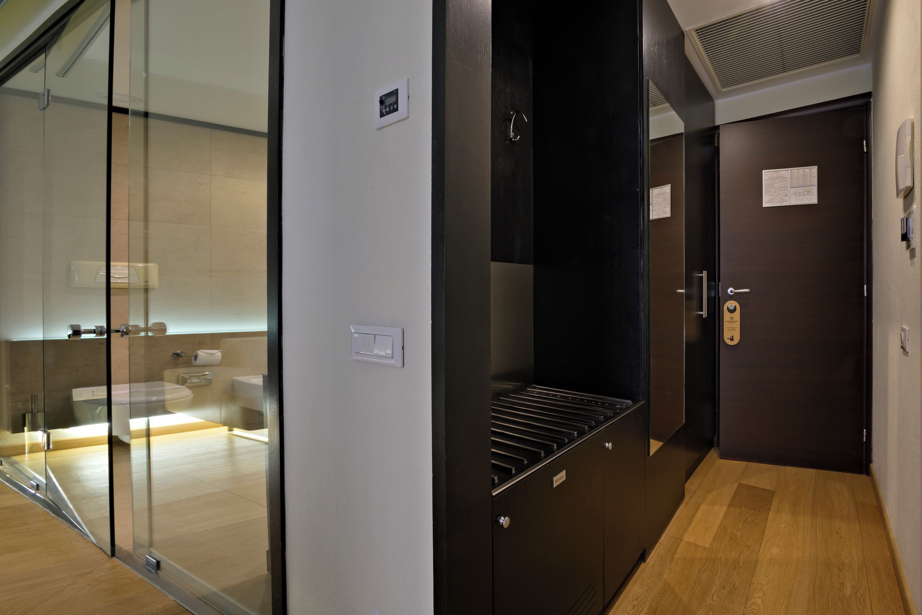 A modern bathroom with a glass shower enclosure, a toilet, and a sink.