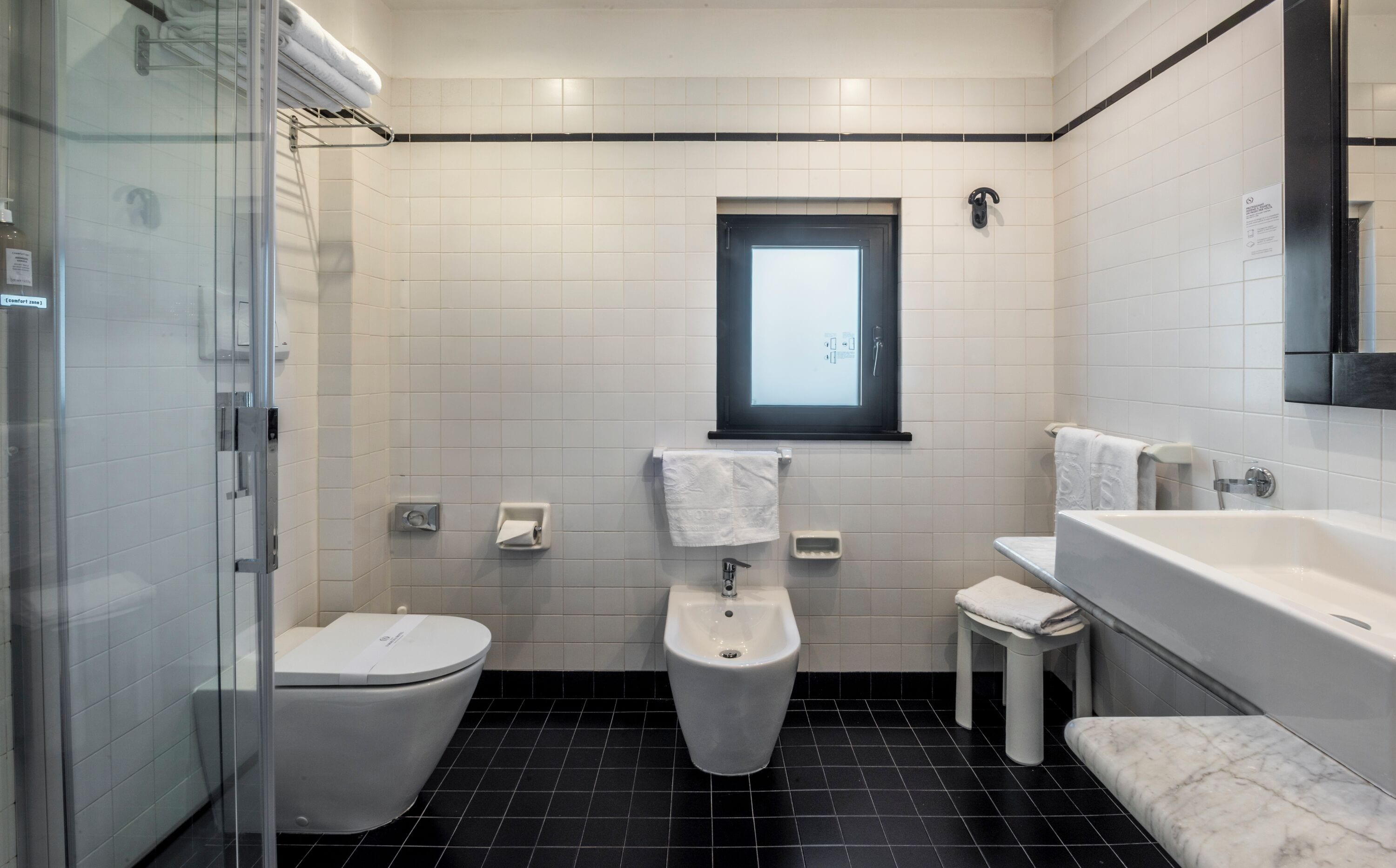 A modern bathroom with a toilet, bidet, and bathtub.
