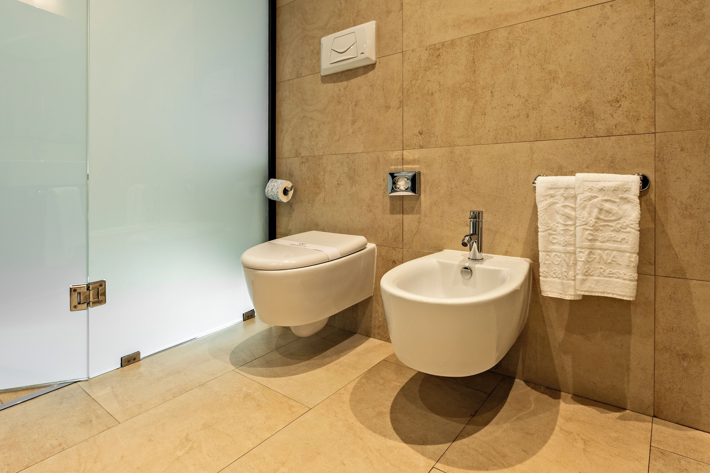 Un baño moderno con inodoro, bidé y lavamanos.