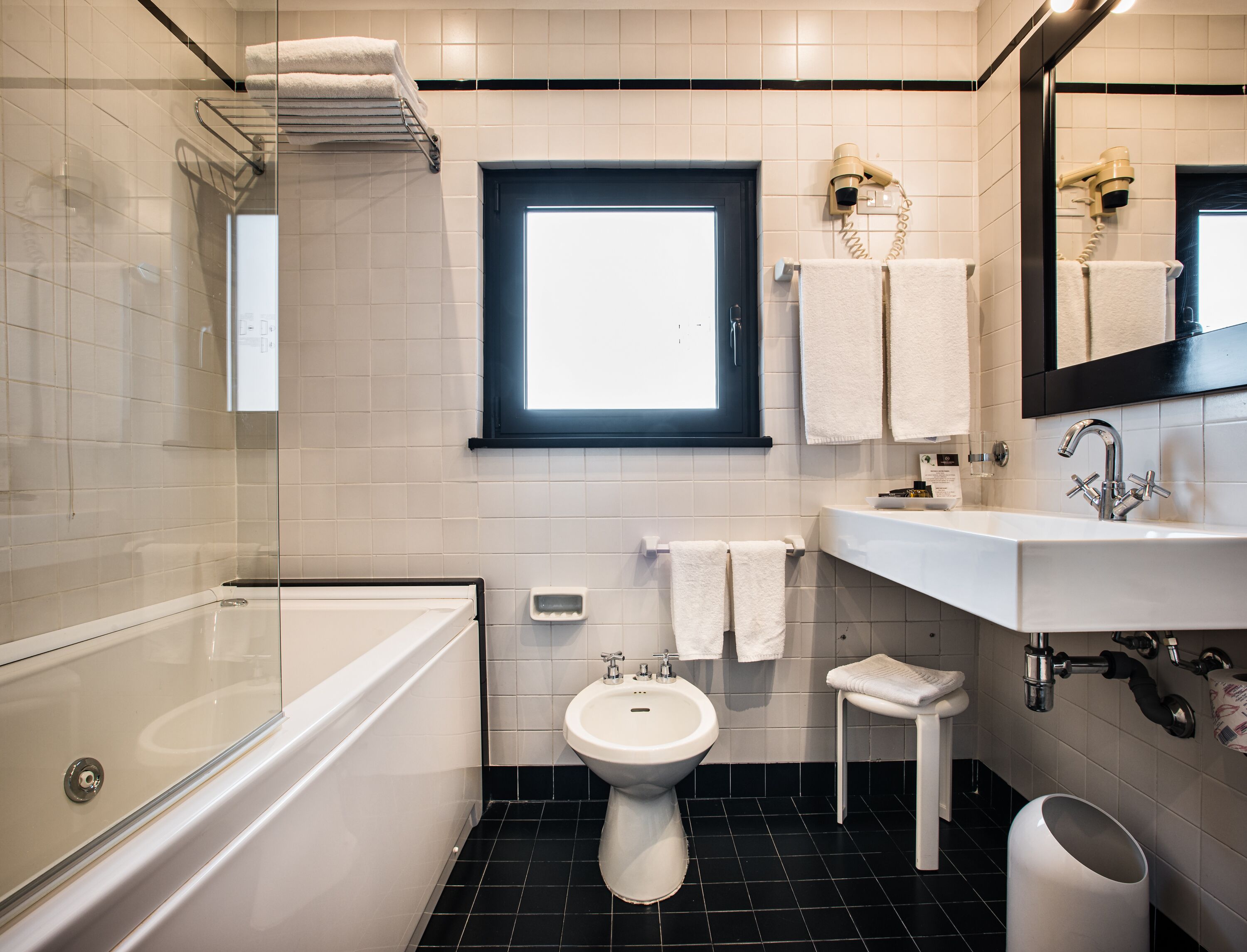 Une salle de bain moderne avec une baignoire, un lavabo, des toilettes et une fenêtre.