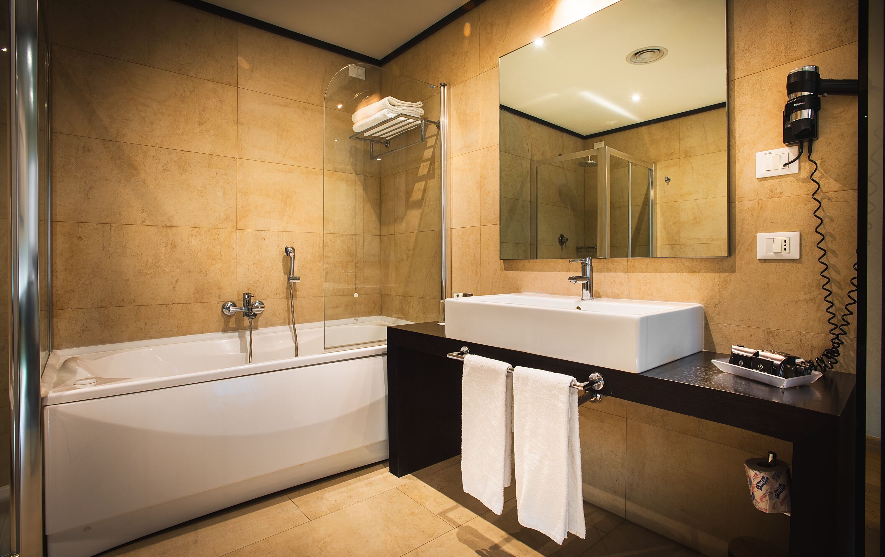 A modern bathroom with a bathtub, a sink, and a mirror.