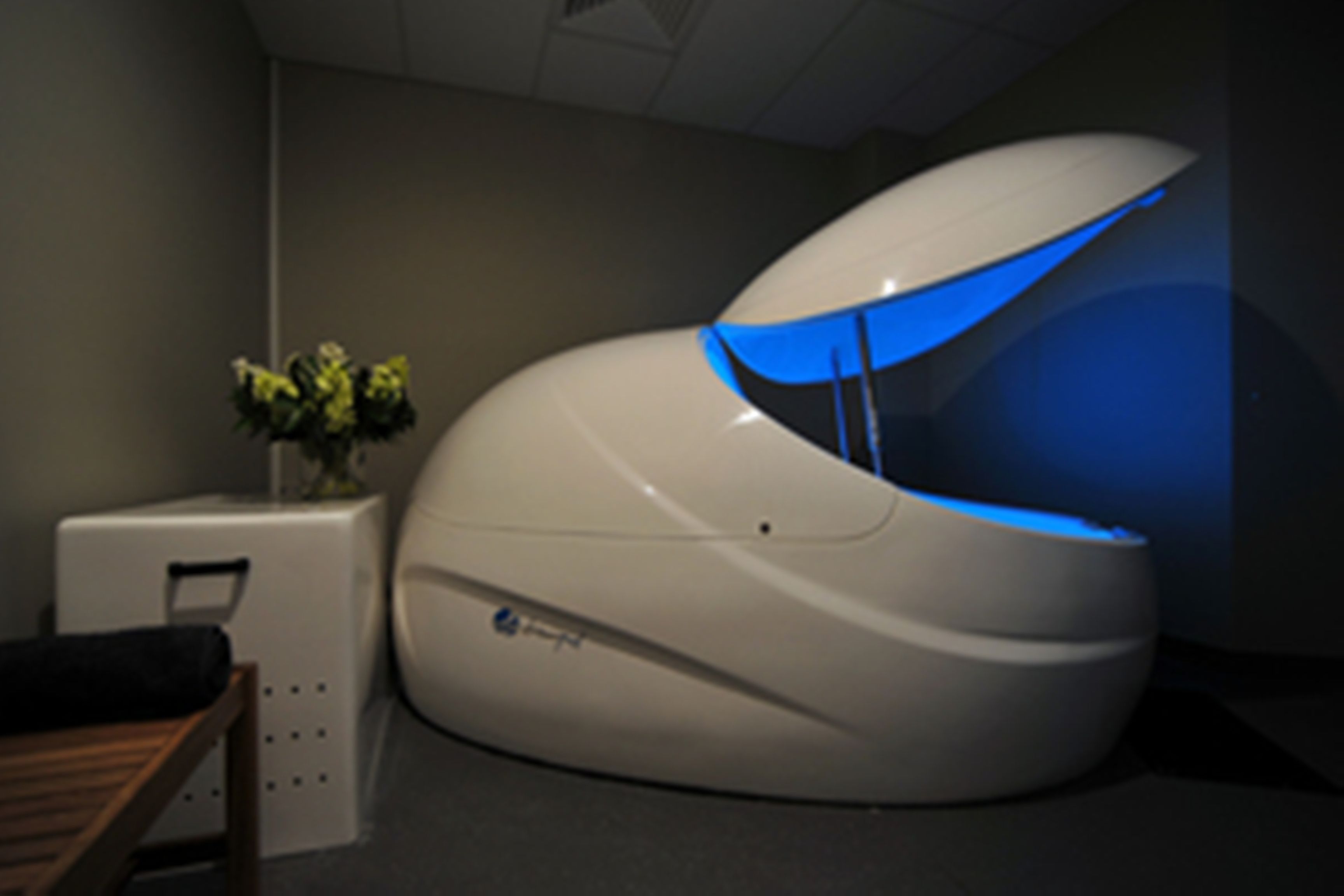 A modern, white, curved room with a blue-lit interior.