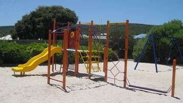 A playground with a yellow slide and climbing structures.