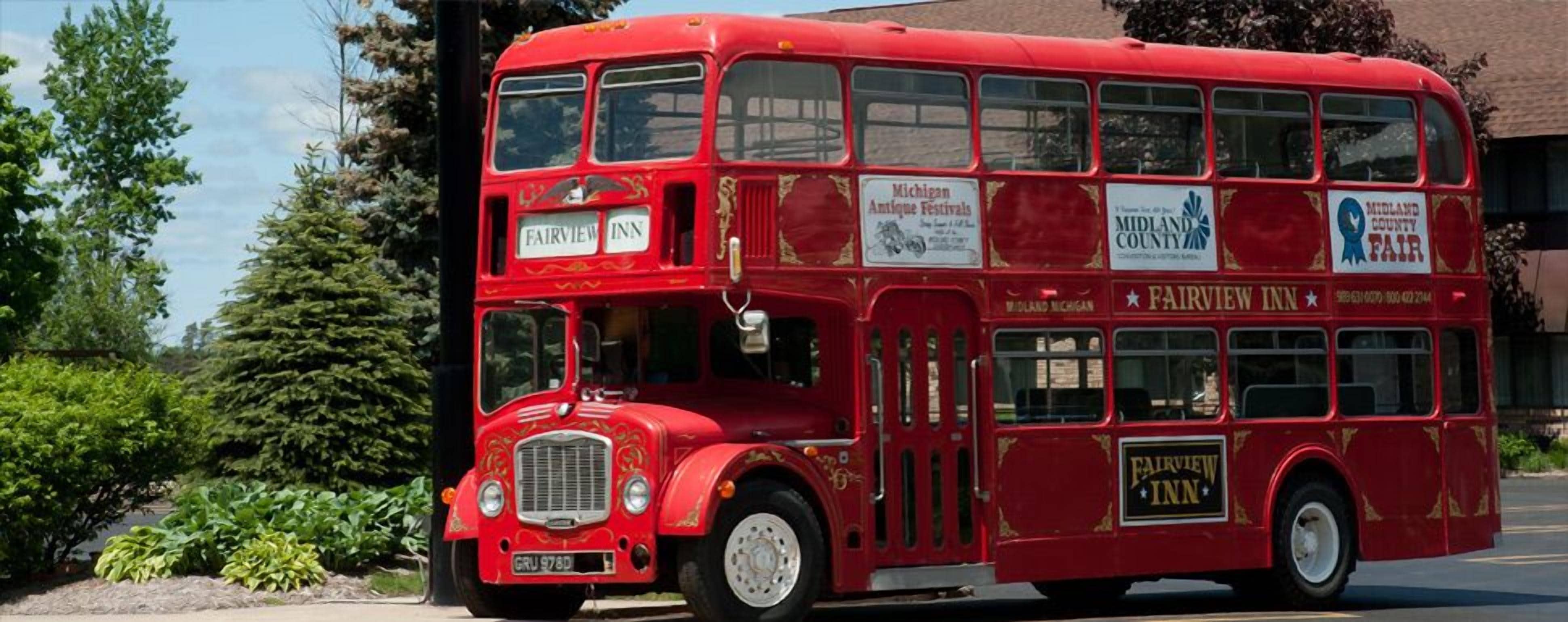 En rød toetagebus med reklamer for Fairview Inn og Michigan Antique Festivals.
