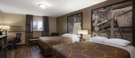 A hotel room with two beds, a desk, a chair, and a large wall mural.