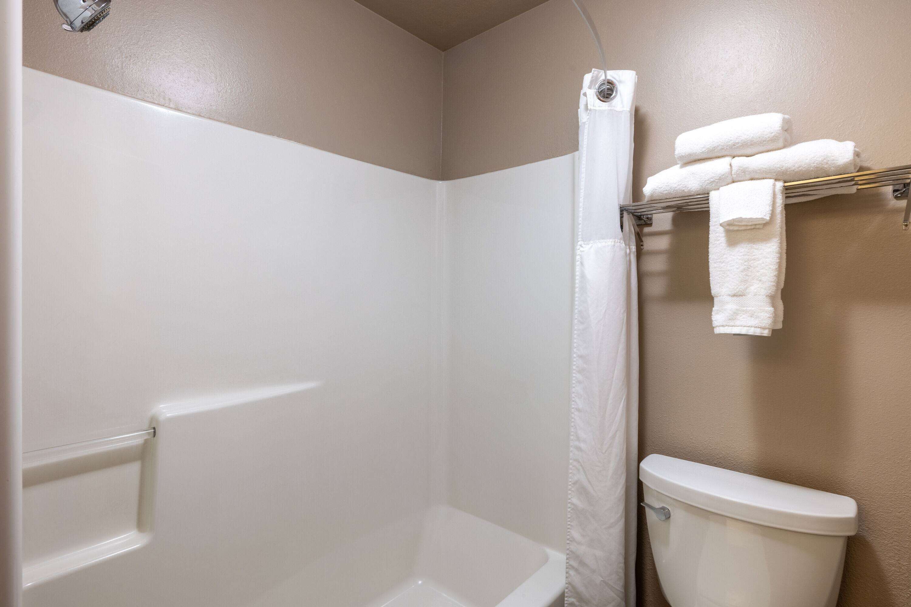 Ein Badezimmer mit Dusche, Toilette und Handtuchhalter.