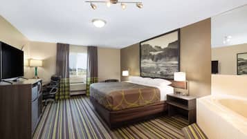 A hotel room with a bed, a desk with a TV, a desk lamp, a chair, a window with curtains, a painting on the wall, a bathroom with a bathtub, and a carpeted floor.