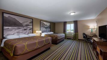 Ein Hotelzimmer mit zwei Betten, einem Schreibtisch, einem Stuhl, einem Fernseher und einem großen Fenster.
