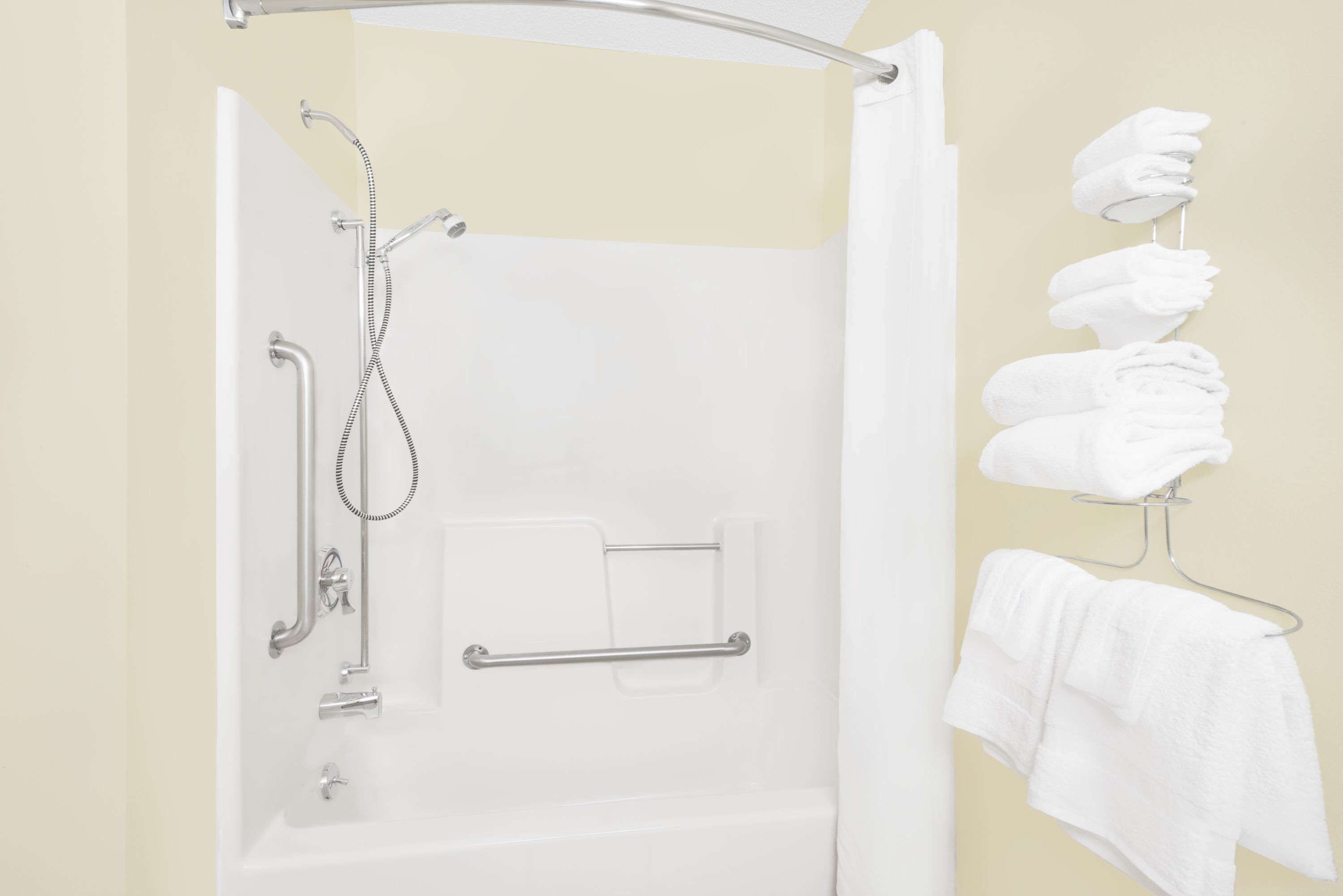 Ein Badezimmer mit Dusche, Handtuchhalter und Handtuchspender.
