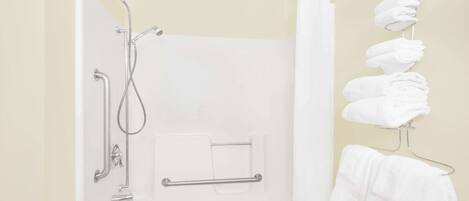 Ein Badezimmer mit Dusche, Handtuchhalter und Handtuchspender.