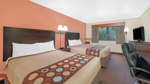 Une chambre d’hôtel avec deux lits, un bureau, une chaise et un téléviseur.