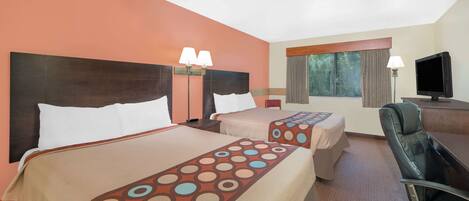 Una habitación de hotel con dos camas, un escritorio, una silla y un televisor.
