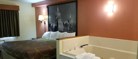 Habitación de hotel con cama, un cuadro grande de un paisaje urbano, un baño con bañera y una ventana con cortinas.