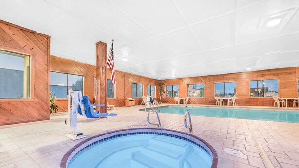 Une piscine intérieure avec un revêtement intérieur en bois, un poste de surveillance pour le sauveteur et un drapeau américain.