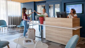 A reception area with a wooden ceiling, a reception desk, and a large window. - ibis Styles Nice Cap 3000 Airport (Saint-Laurent-du-Var)