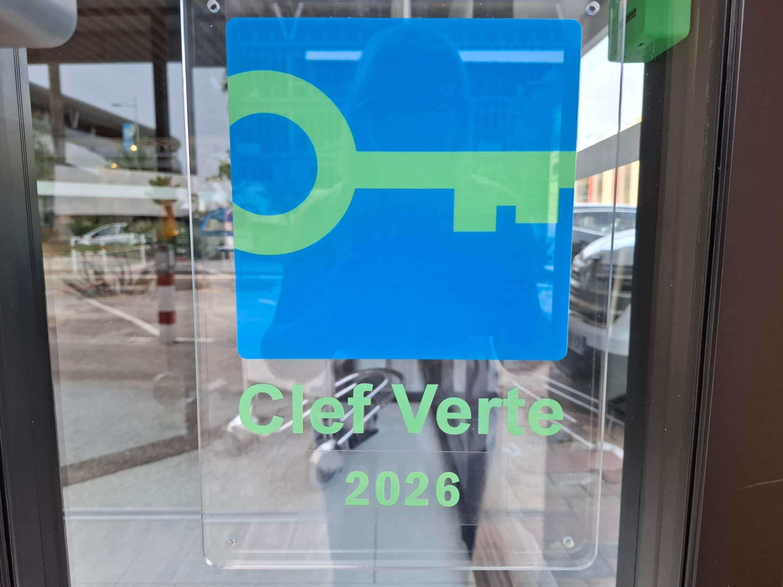 A sign with a key symbol and the text 'Clef Verte 2026' on a glass window.