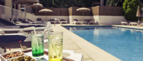 Een seizoensgebonden buitenzwembad, parasols voor strand/zwembad