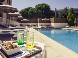 Una piscina al aire libre de temporada, sombrillas