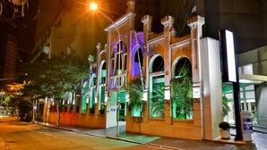 A hotel with a classic architectural style, featuring arched windows and a well-lit facade. - SLAVIERO Downtown São Paulo (São Paulo)