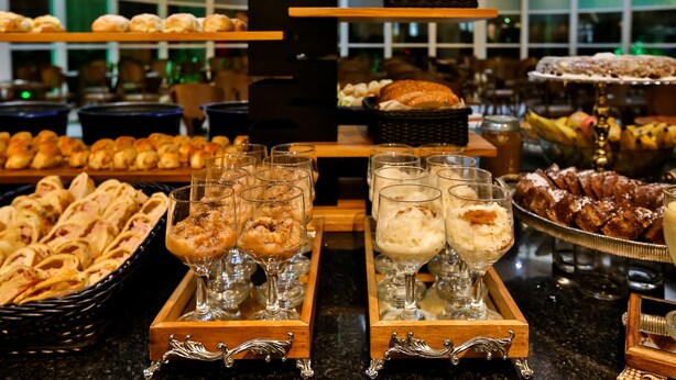 A buffet with various food items and desserts, including pastries, bread, and fruit. - SLAVIERO Downtown São Paulo (São Paulo)