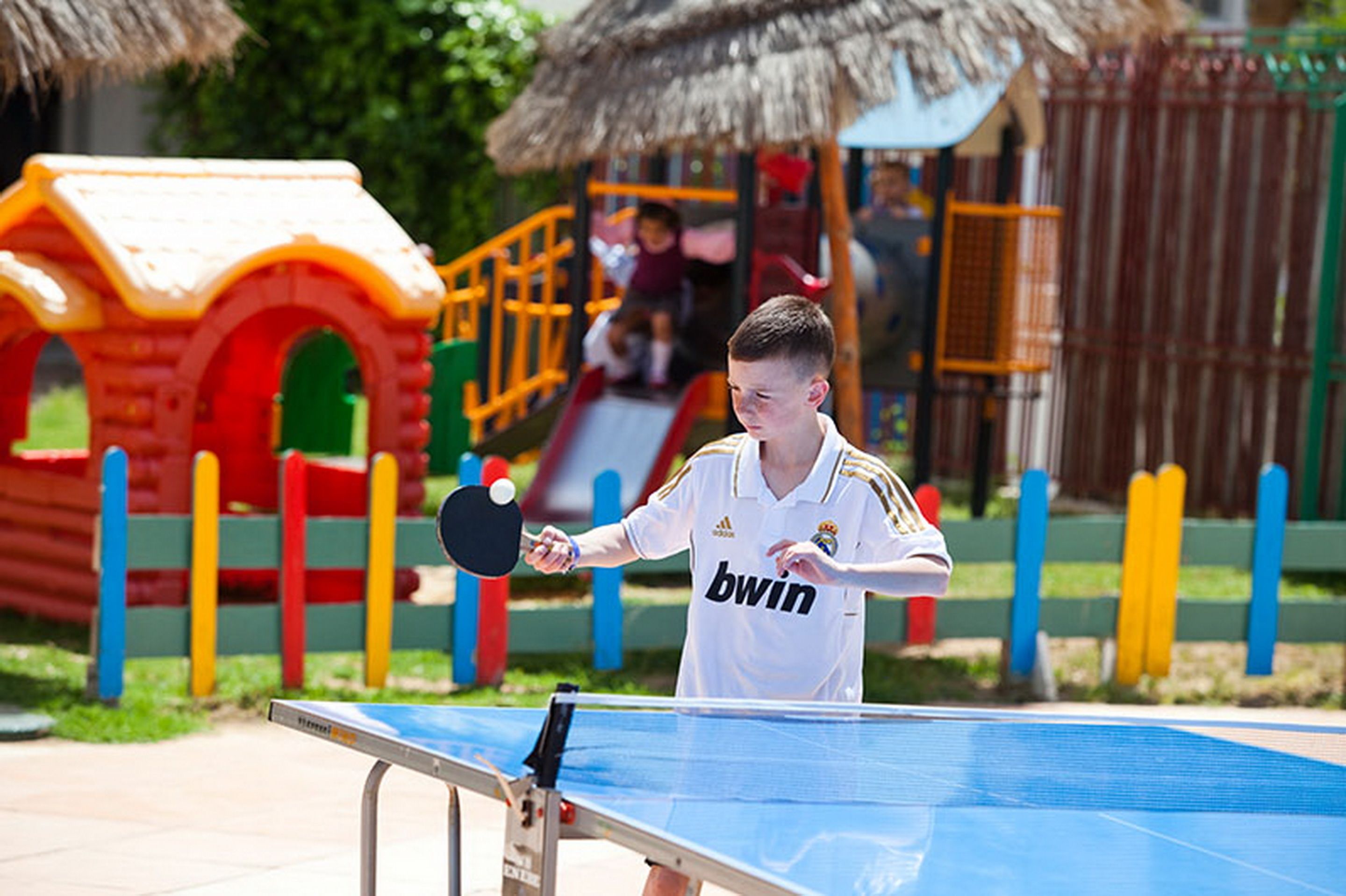 A table tennis table with a net in an outdoor setting.